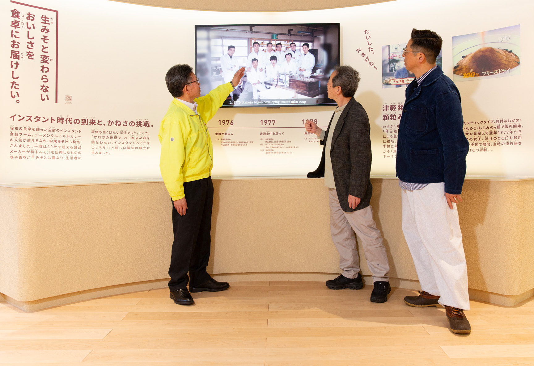 「顆粒みその誕生」の展示室内。左から秋田谷氏、石井、髙橋。当時の開発チームの写真には、秋田谷氏自身も写っている